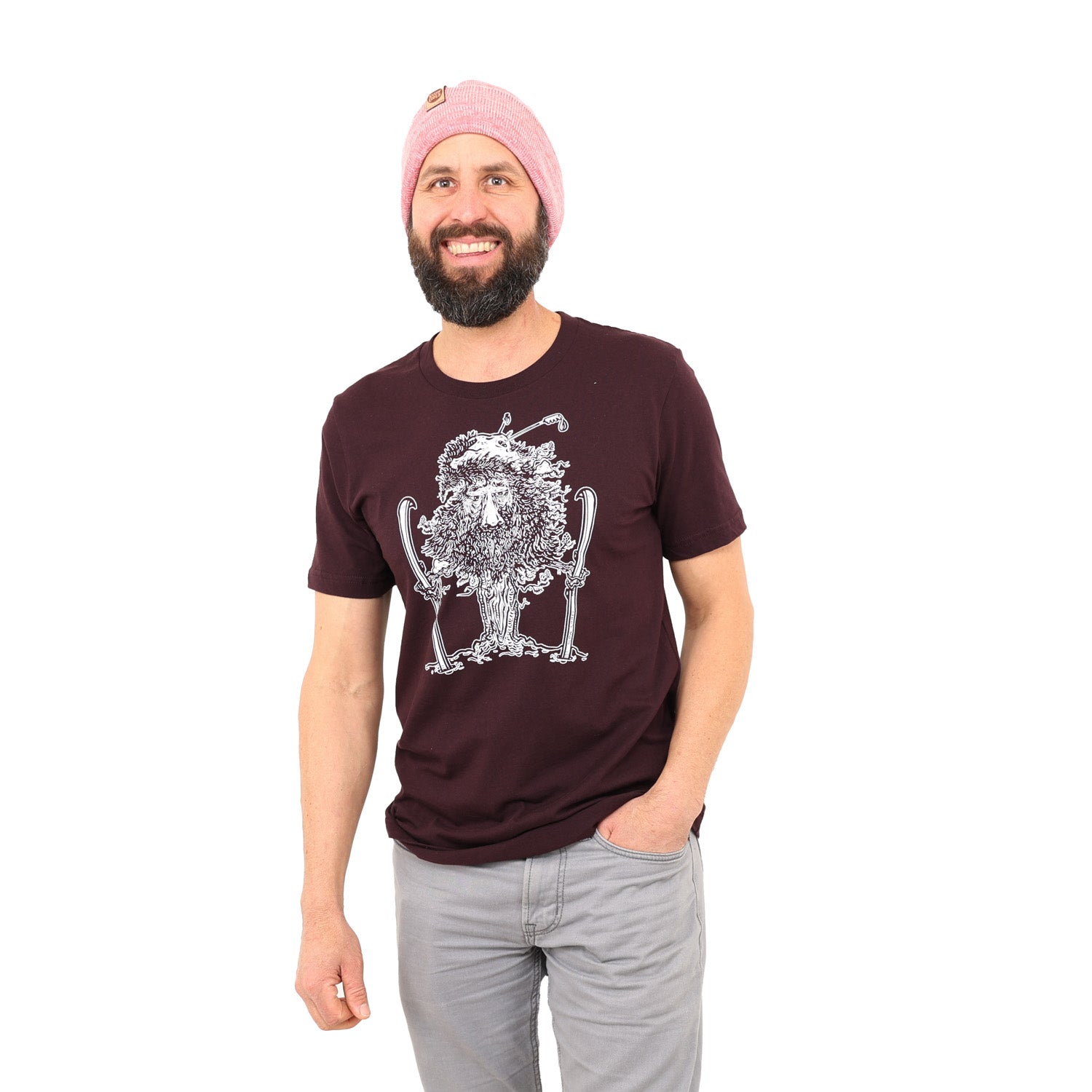 Man wearing maroon t shirt with white print of close up of tree man holding skis with ski poles in his top branches
