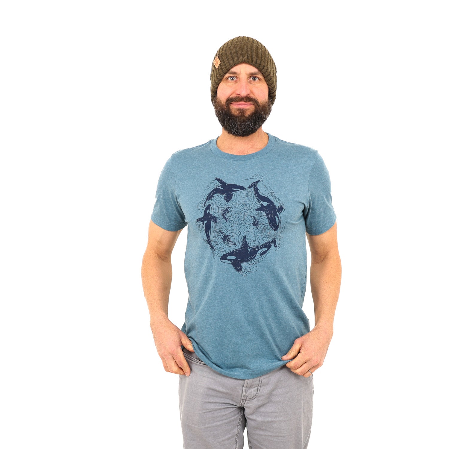 Bearded man wearing beanie with light blue shirt and dark blue print of orcas swimming in a circle
