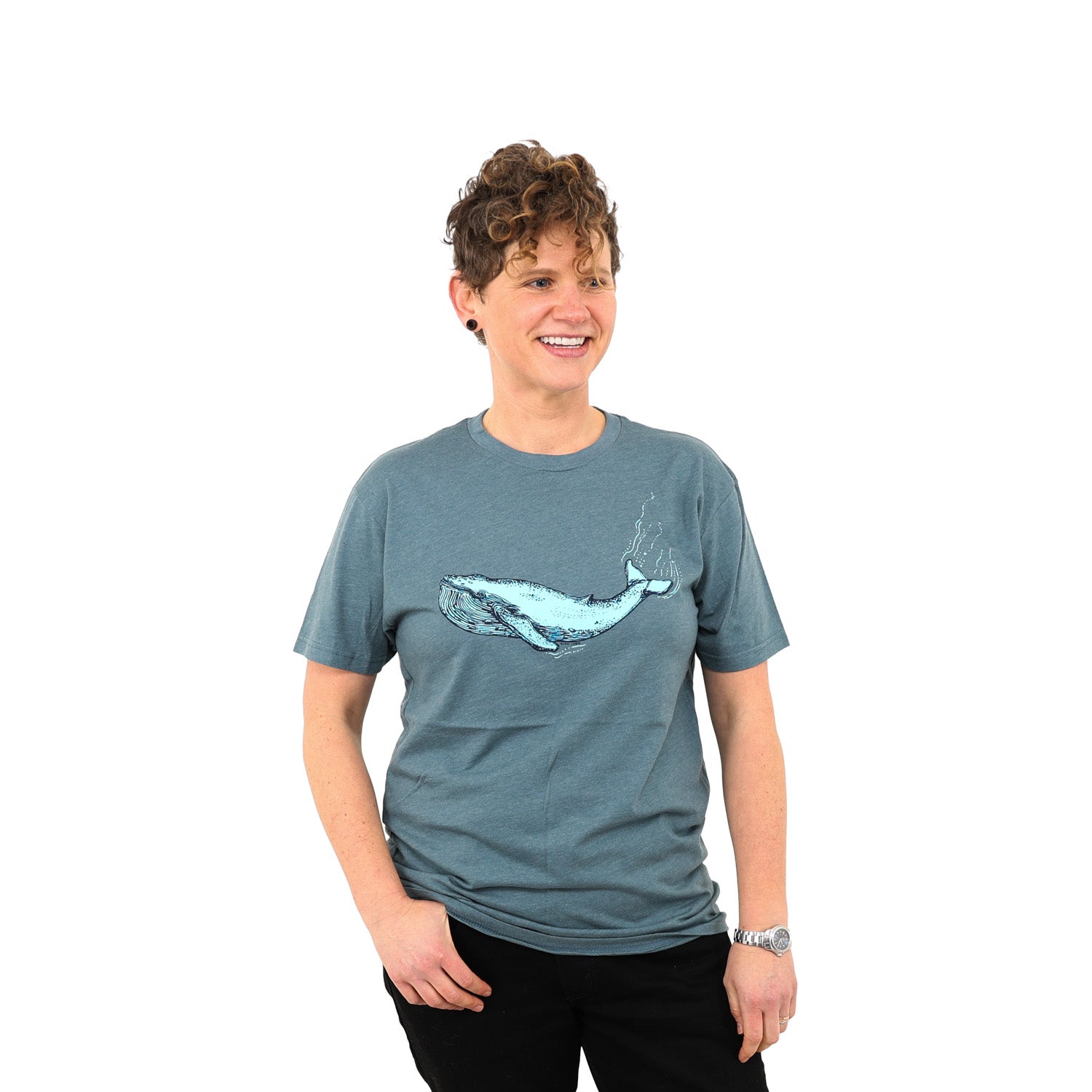 Woman with super cool short curly hear wearing a blue/grey t-shirt with a blue whale on it.