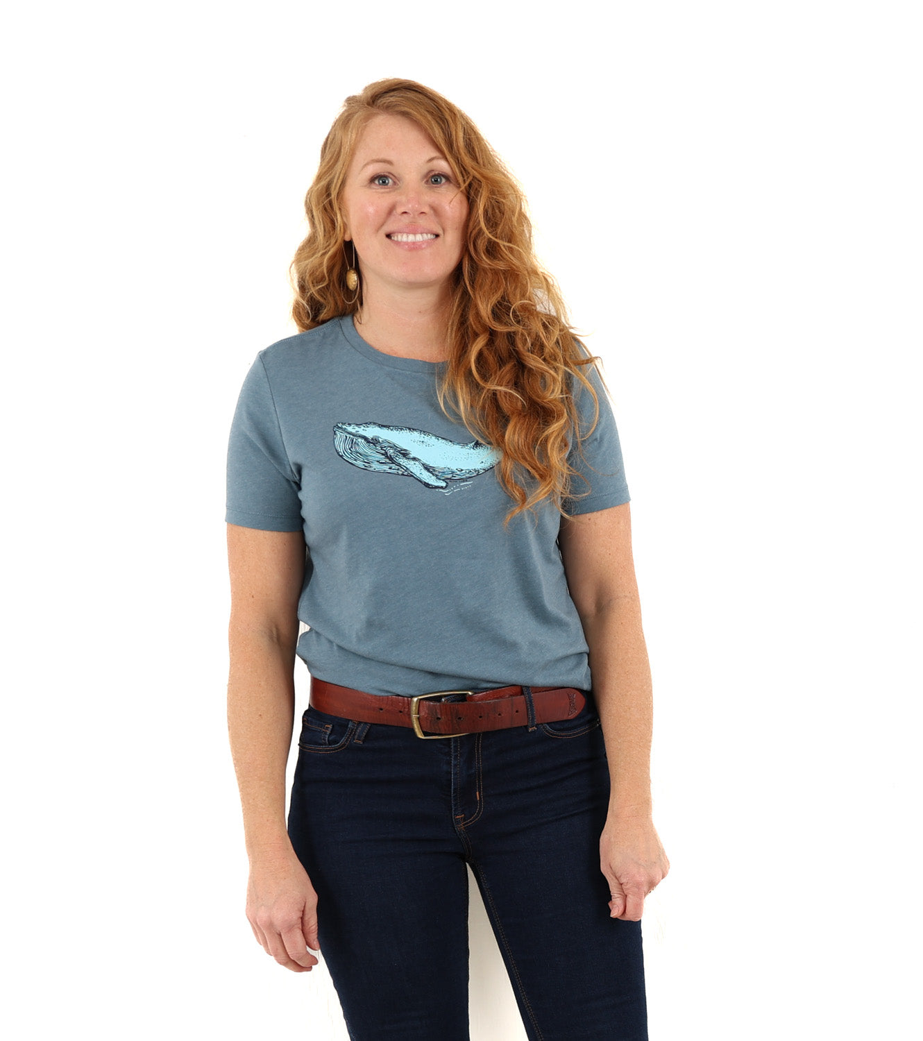 woman standing while wearing a blue t shirt with a blue whale screen printed across the chest/boob zone.