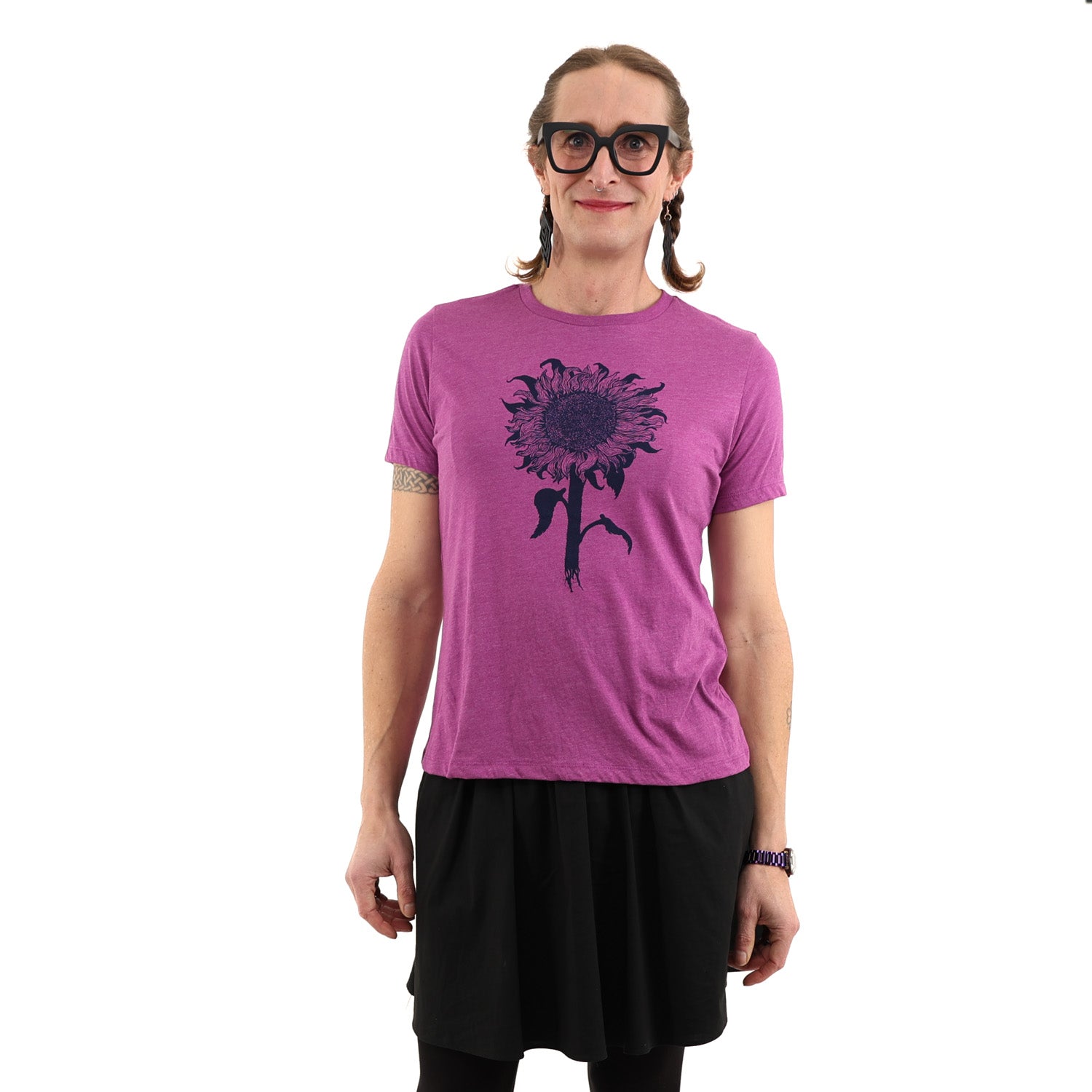 Woman wearing purple tinted pink shirt with a sunflower printed in dark navy ink