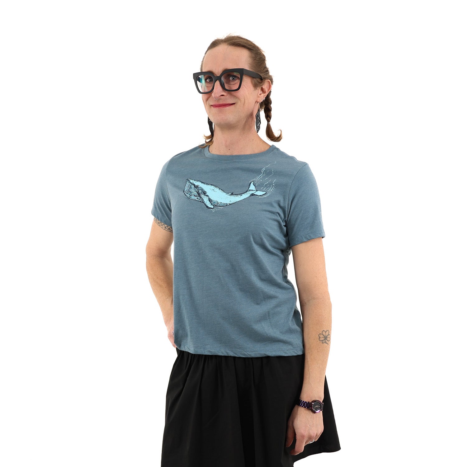 woman standing while wearing a blue t shirt with a blue whale screen printed across the chest/boob zone.