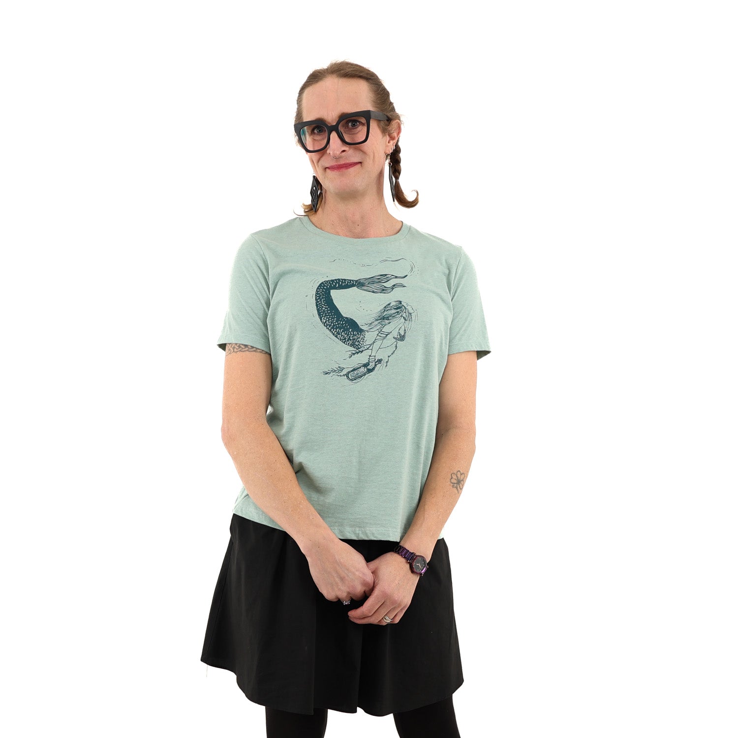 Woman wearing light green t shirt with a mermaid printed in green ink
