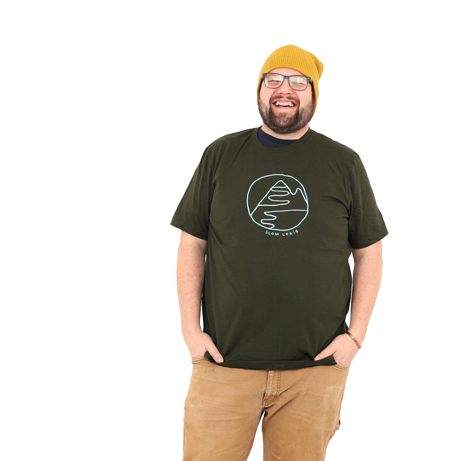 super happy guy wearing glasses and a mustard colored hat. Man has dark green t-shirt with light blue ink of the Slow Loris mountain hug design.