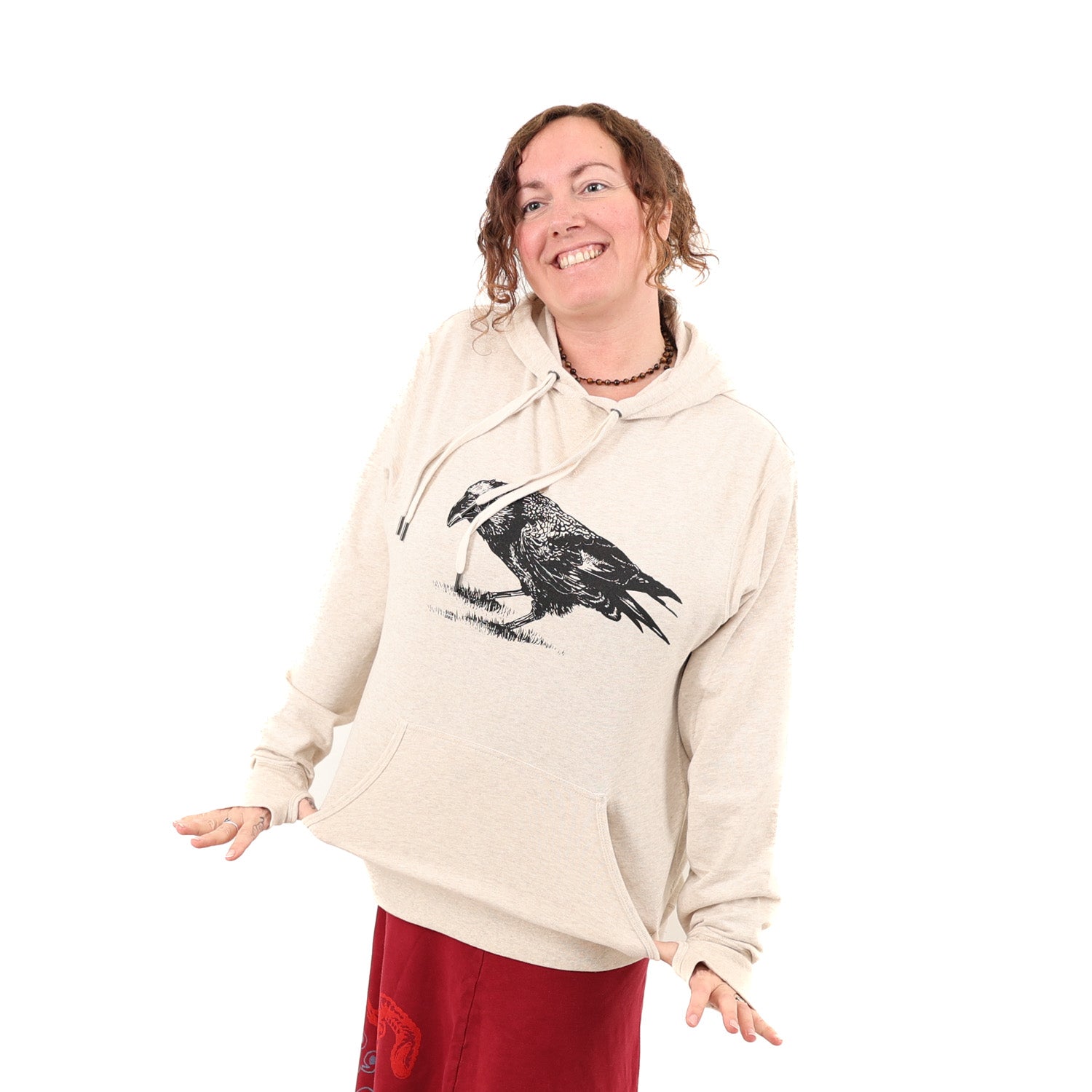 Girl wearing tan/white hoodie with a black print of a crow.