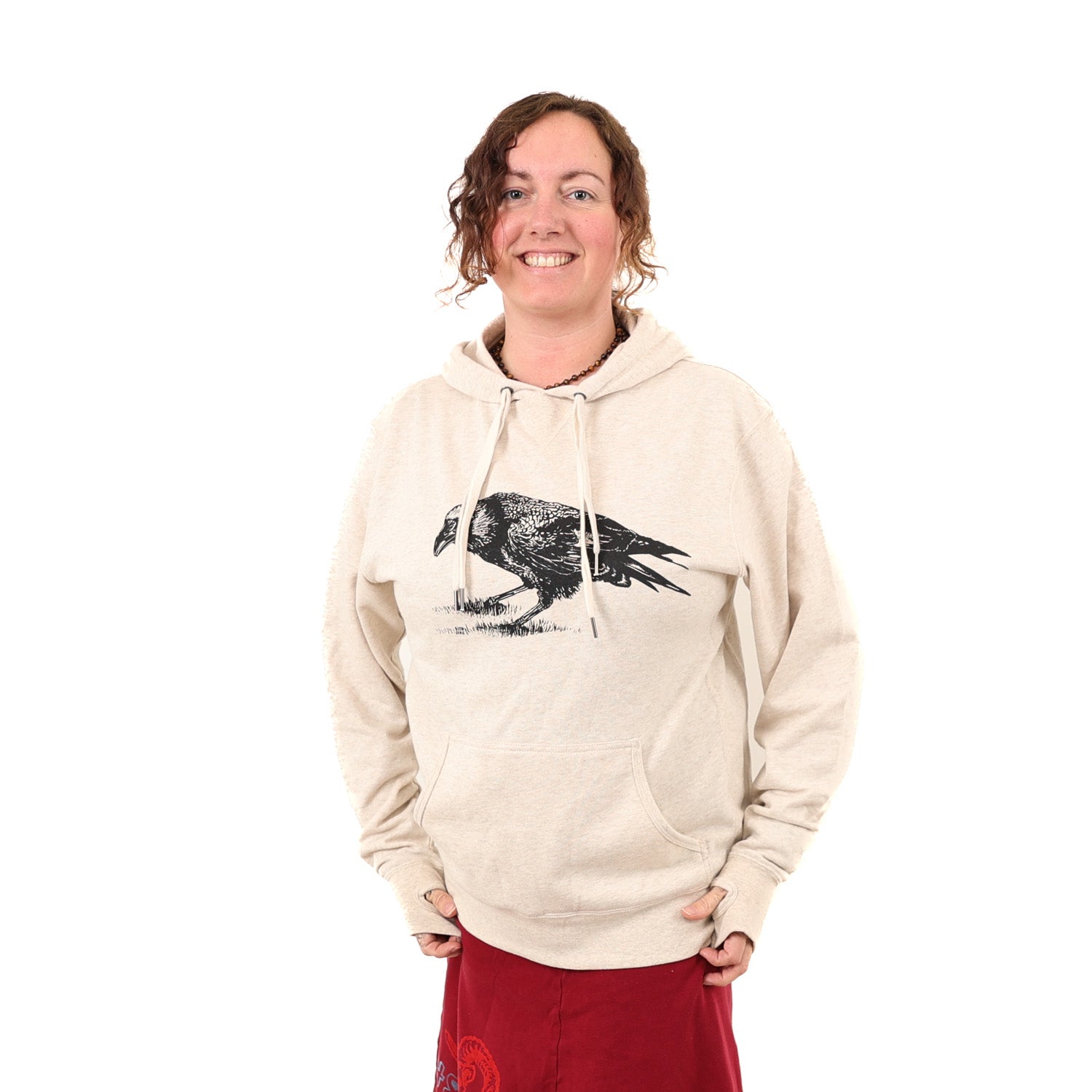 Girl wearing tan/white hoodie with a black print of a crow.