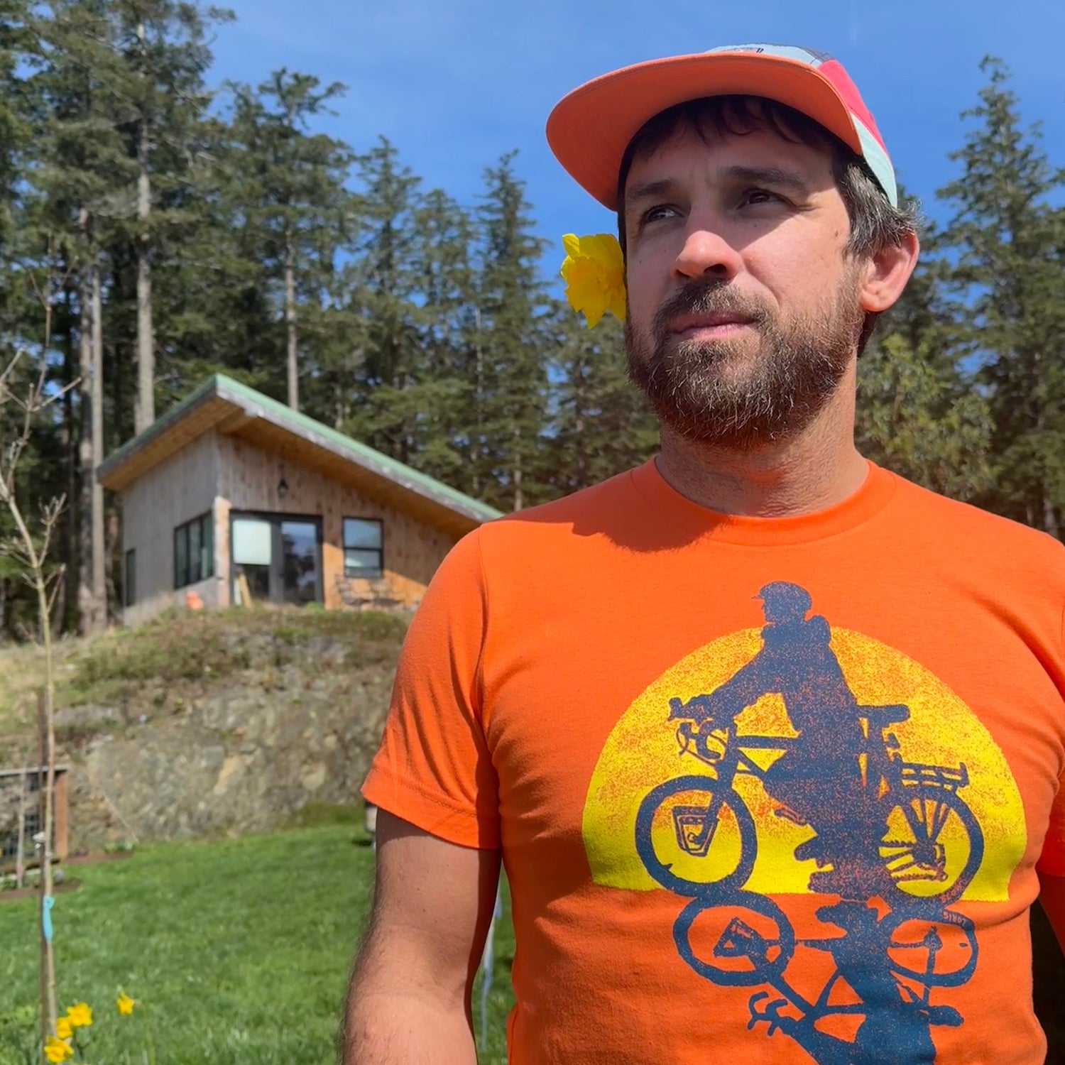 man wearing orange shirt with bicyclist printed