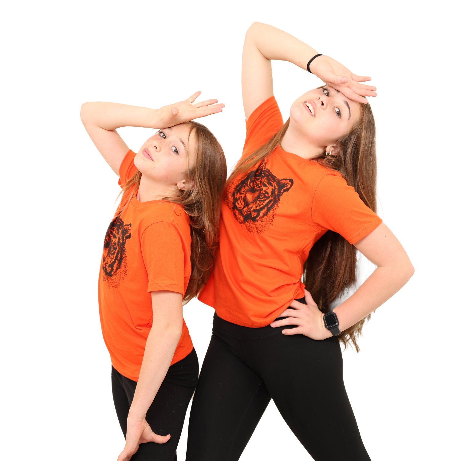 two girls with heads kicked back and hands on forehead while wearing a bright orange t shirt with tiger prints