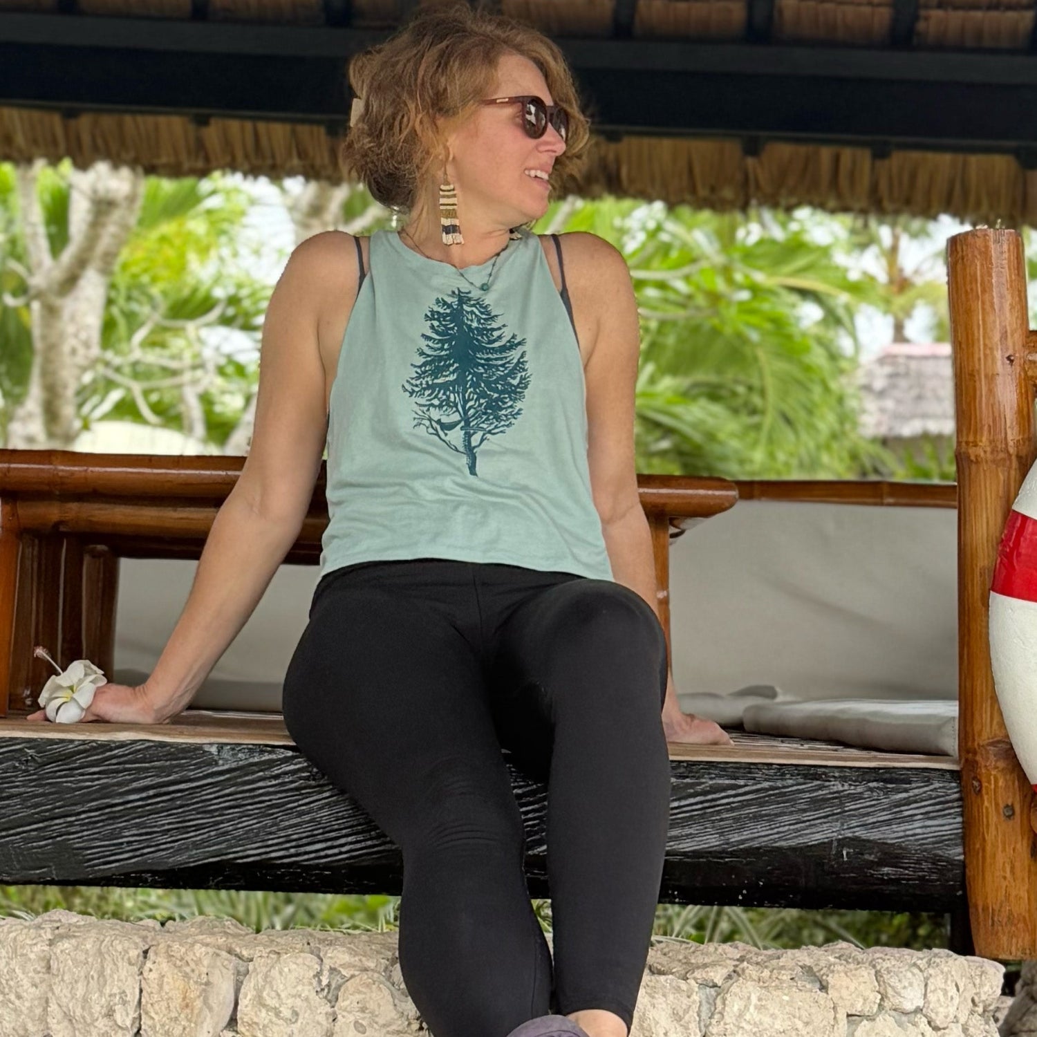Girl sitting holding flower and looking to the side