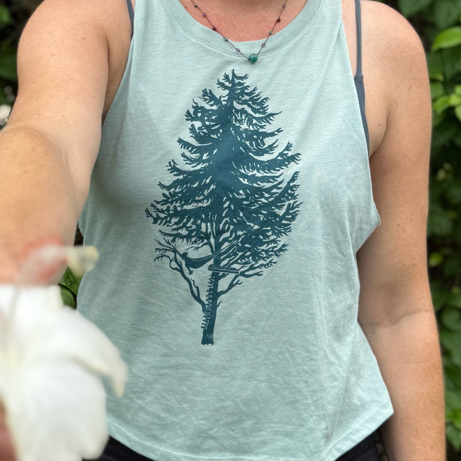 girl wearing tank holding out flower