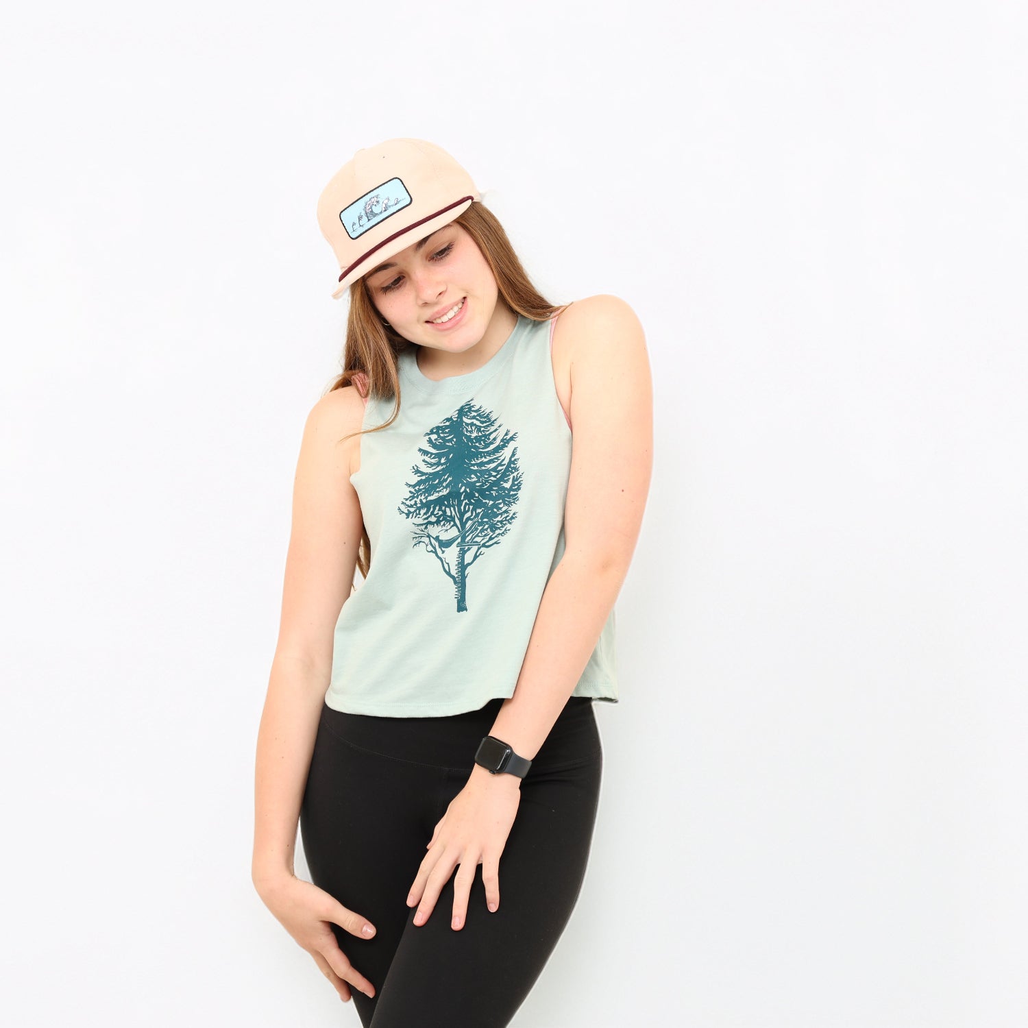 Girl in white backdrop with tank and hat