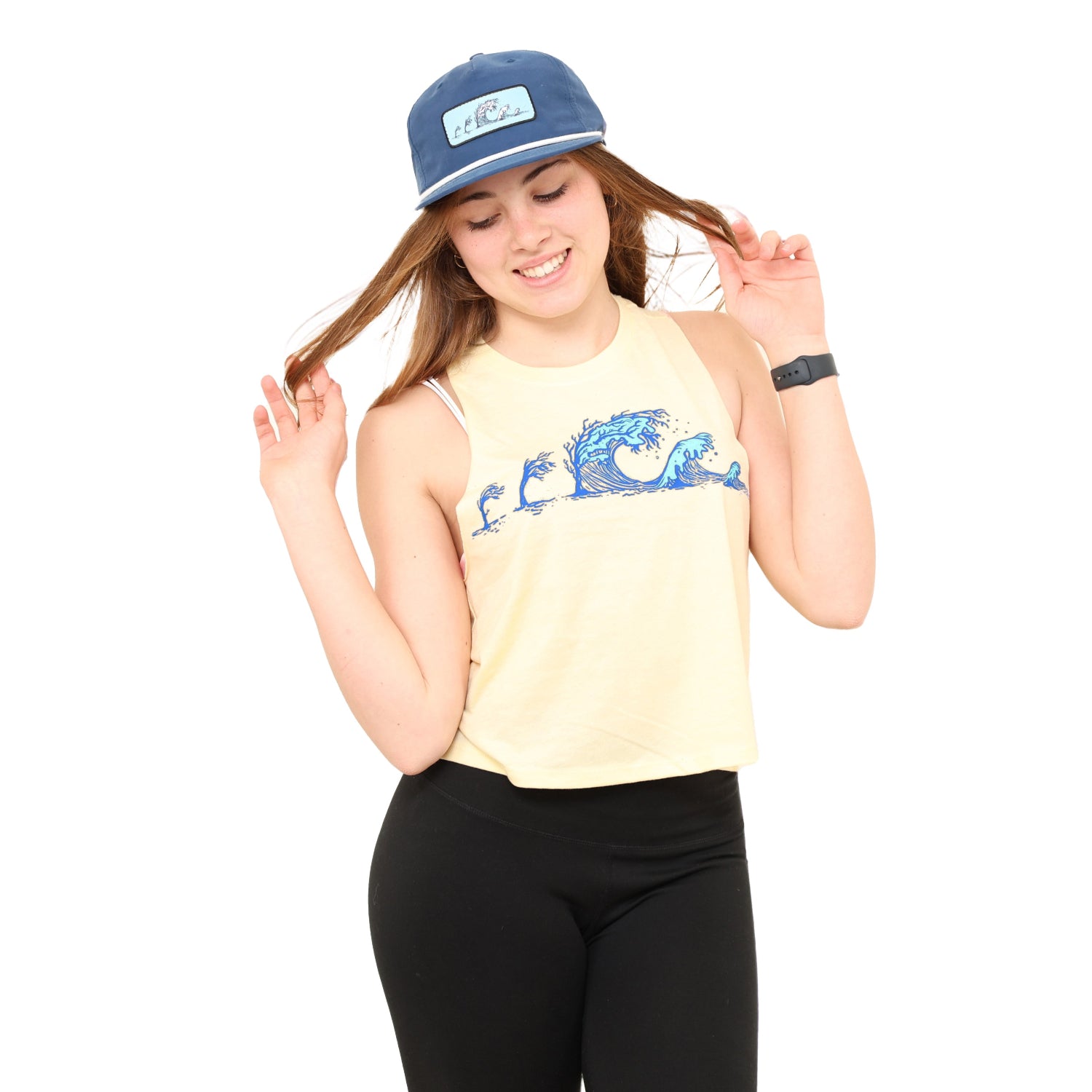 girl holding hair out wearing a soft yellow tank top with the tree wave print on it.