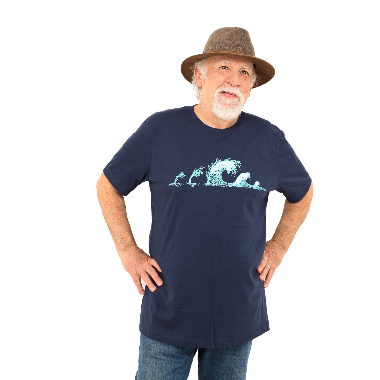 Man standing with hands on his hips while wearing a dark blue shirt with trees turning into waves in white and light blue ink