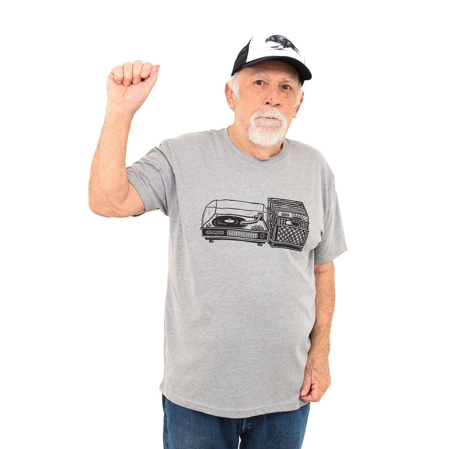 man wearing light grey shirt with black print of a record player with a milk crate full of records next to it.