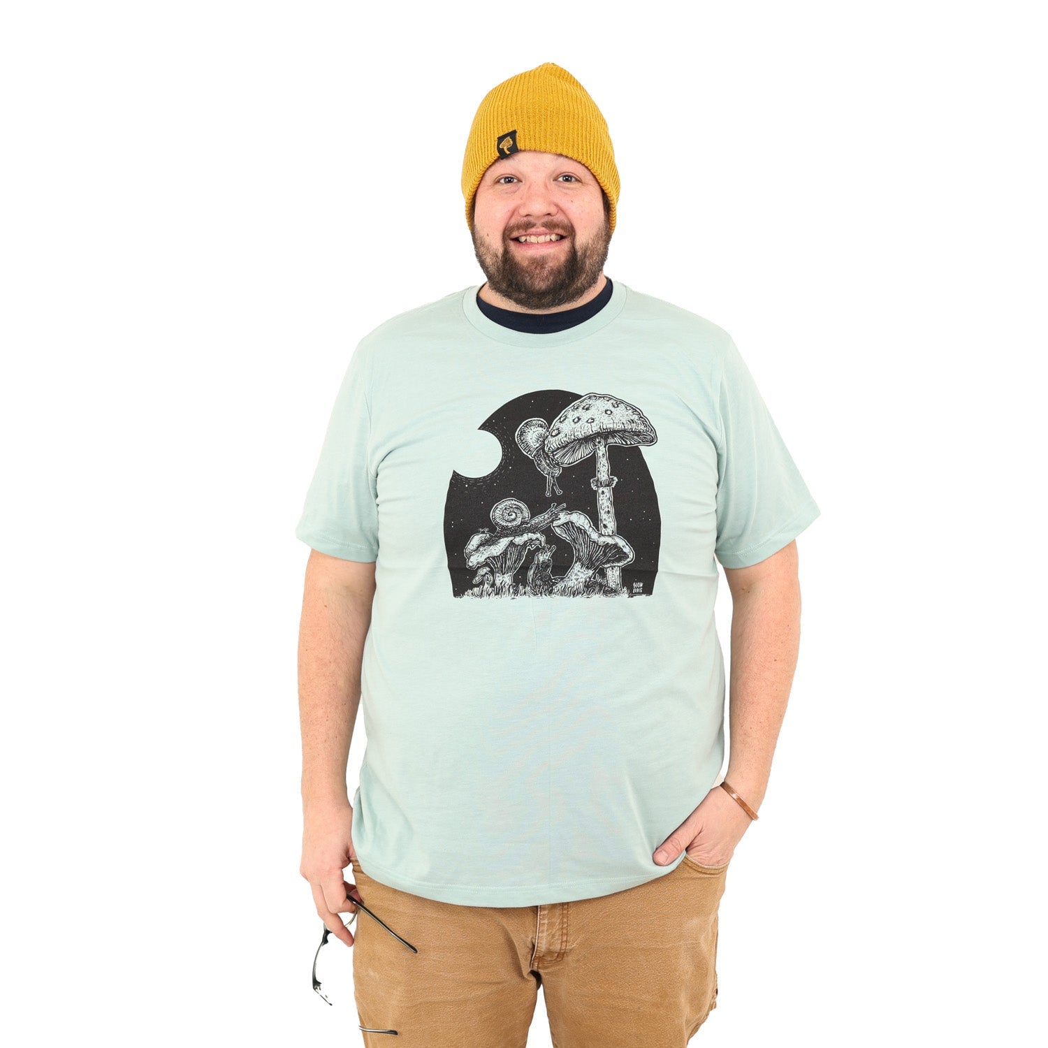 Happy guy wearing mustard beanie and light mint shirt with snails eating mushrooms in the full moon light.