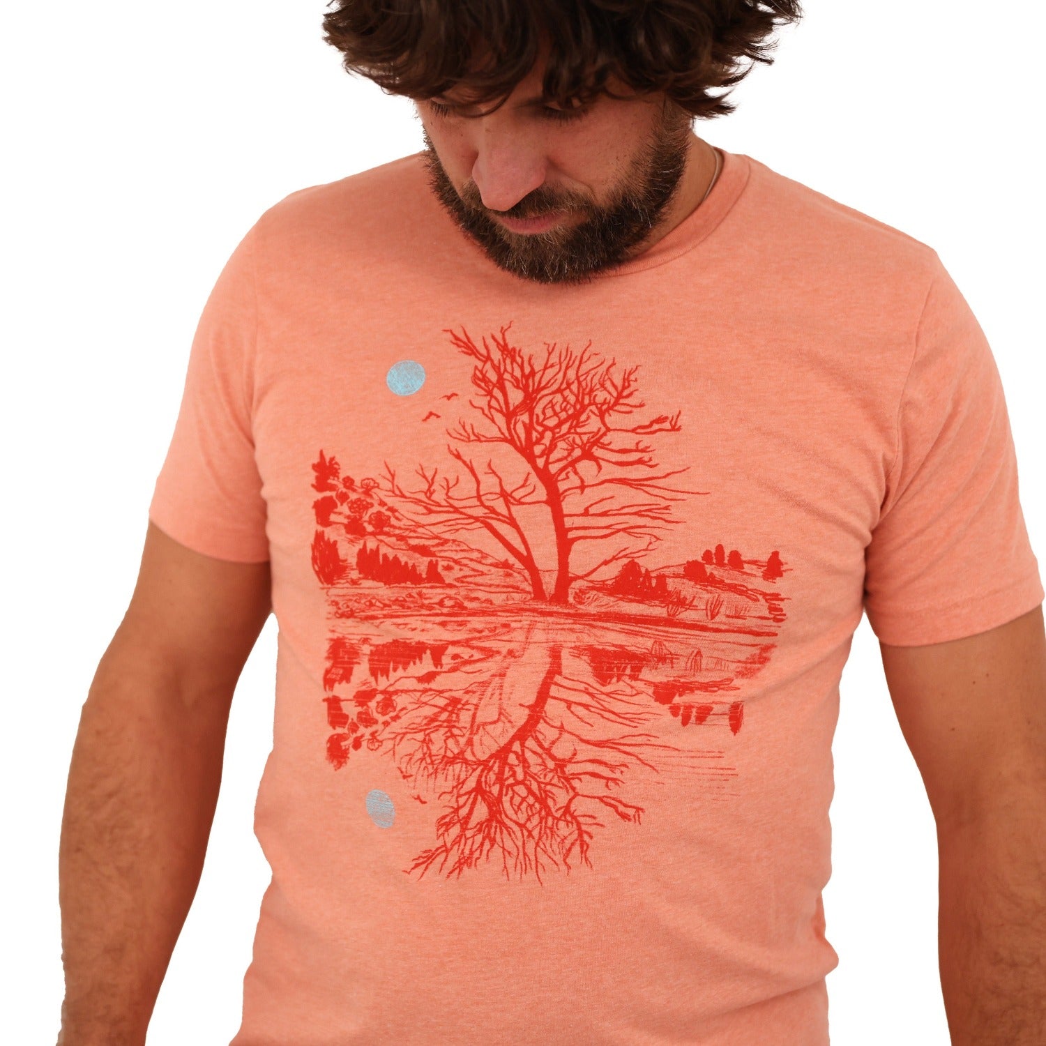 man wearing sunset orange t-shirt with darker orange print of moon and scene reflection over water.