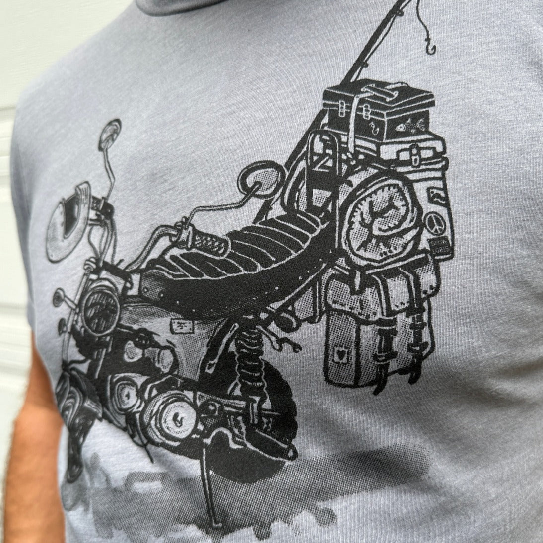 Black print on a grey colored t-shirt. Print is of a mini-bike loaded up with fishing pole, helmet, sleeping bag, and bags.