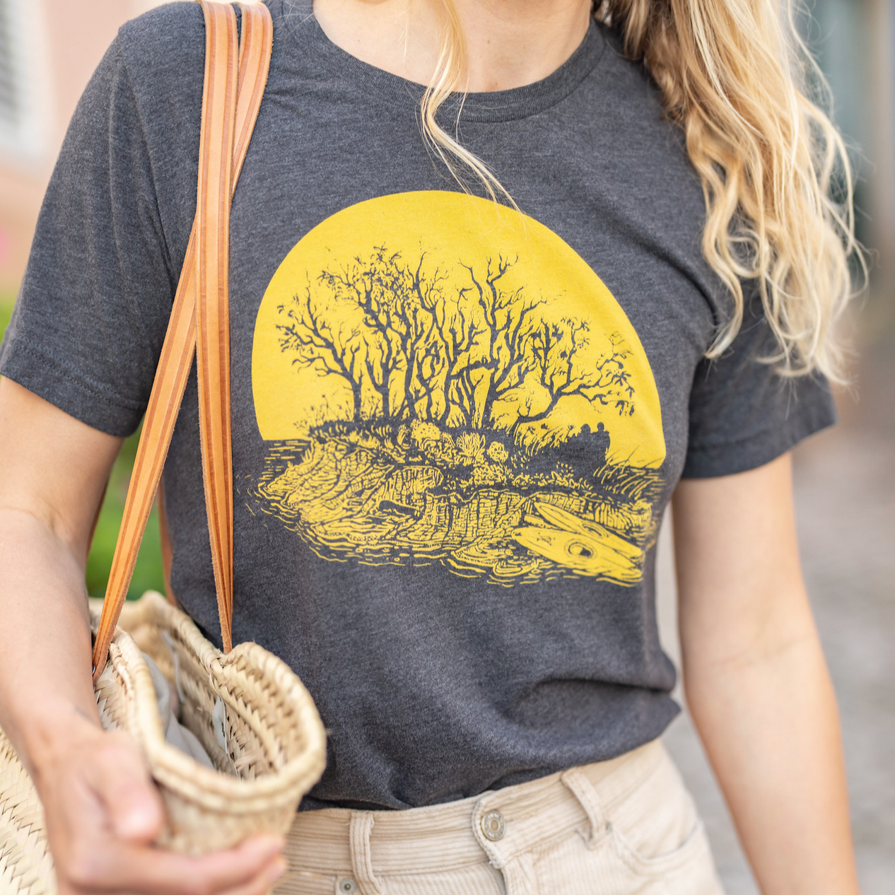 close up of woman wearing kayaker t-shirt- grey with yellow print.