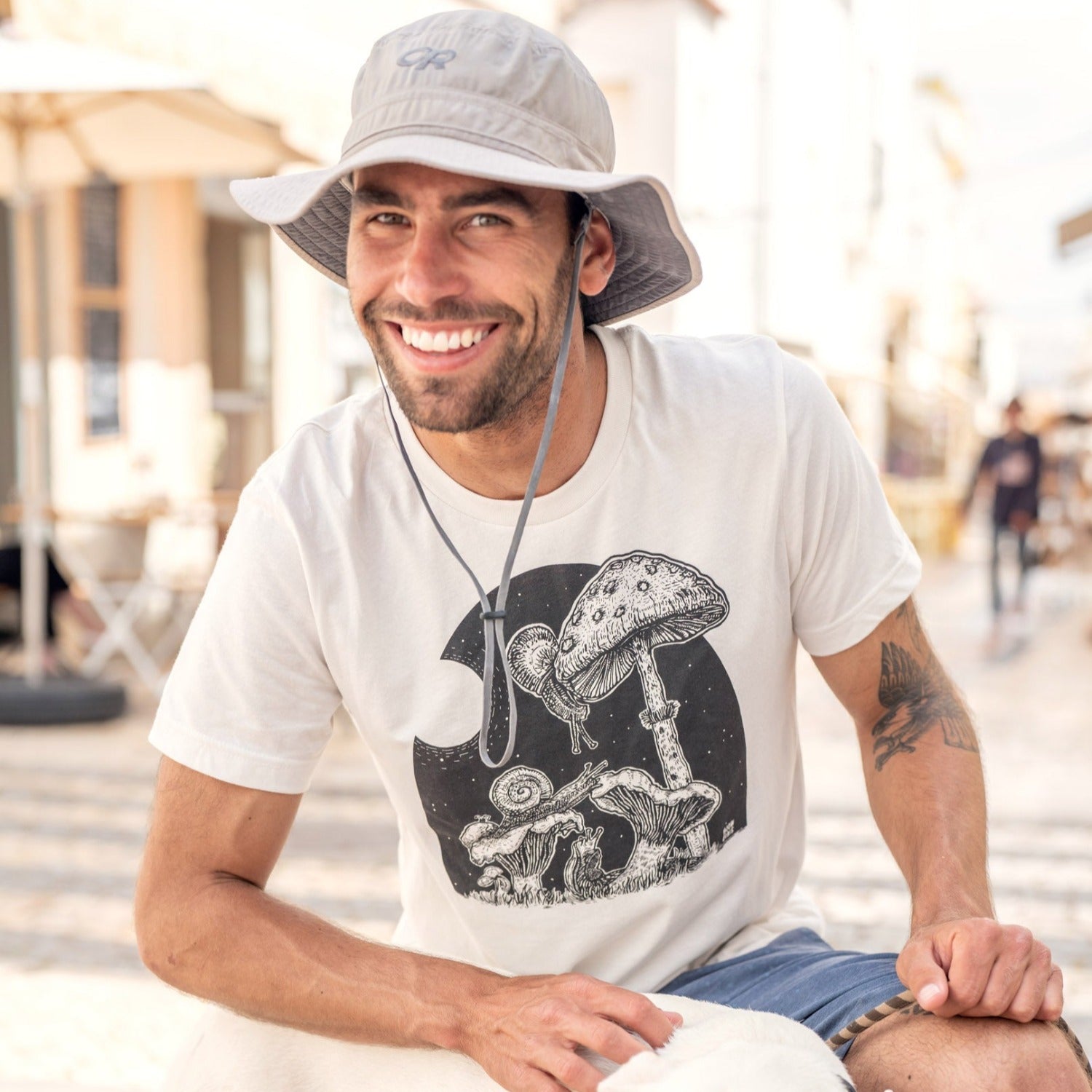 man petting dog while wearing a white shirt with snails eating mushrooms in the full moon light.