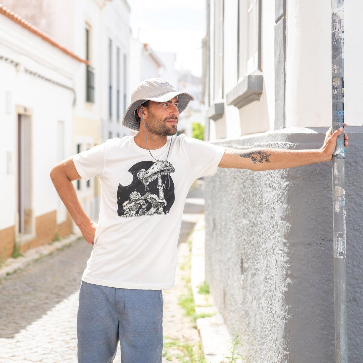 man on street wearing a white shirt with snails eating mushrooms in the full moon light.