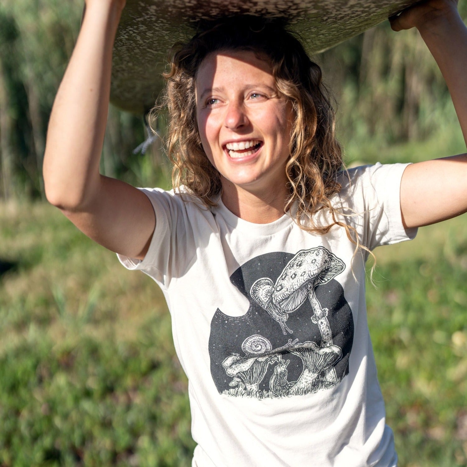 Girl with surfboard over her head wearing a white shirt with snails eating mushrooms in the full moon light.