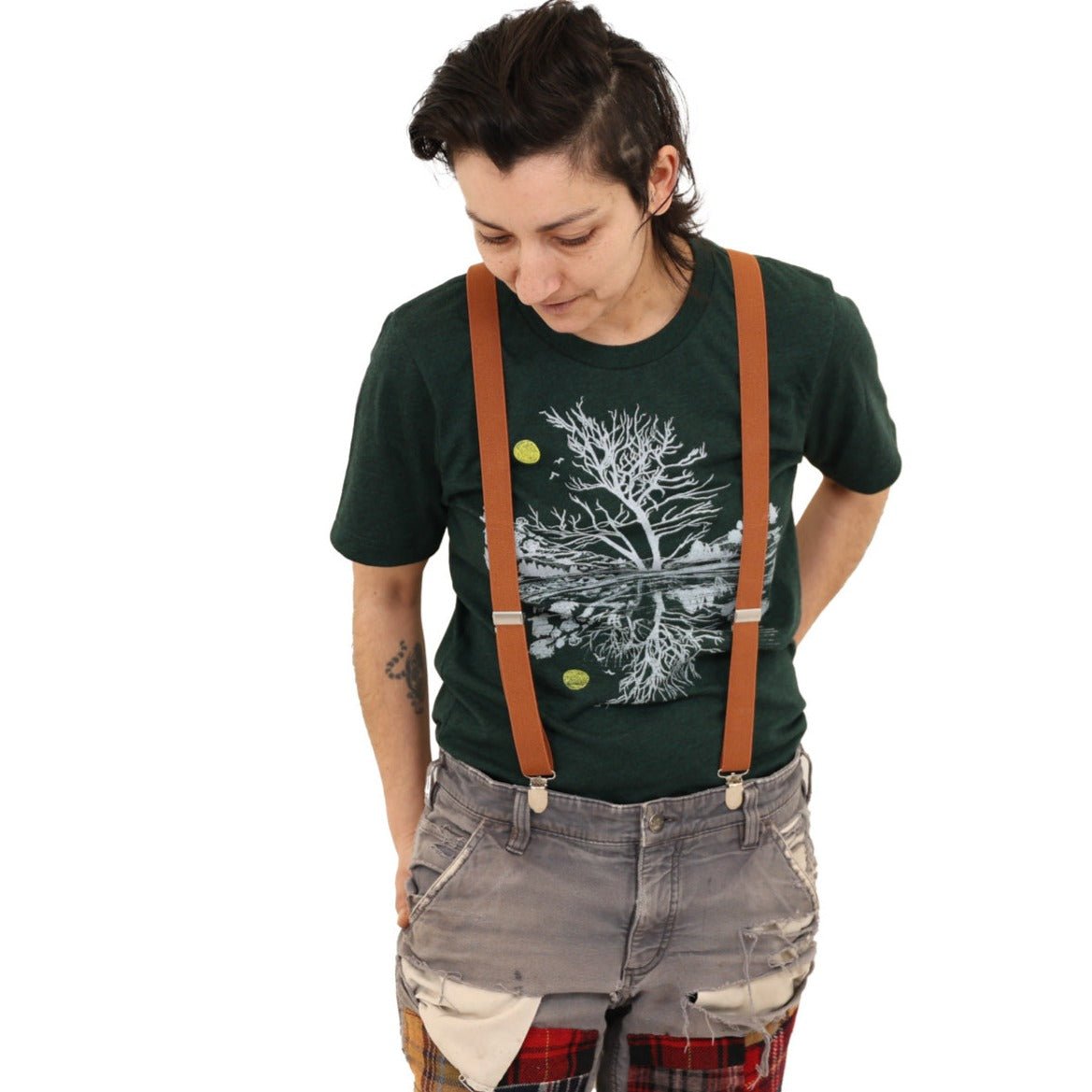 Woman wearing green t-shirt and light ink and a yellow moon with scene reflecting over water.