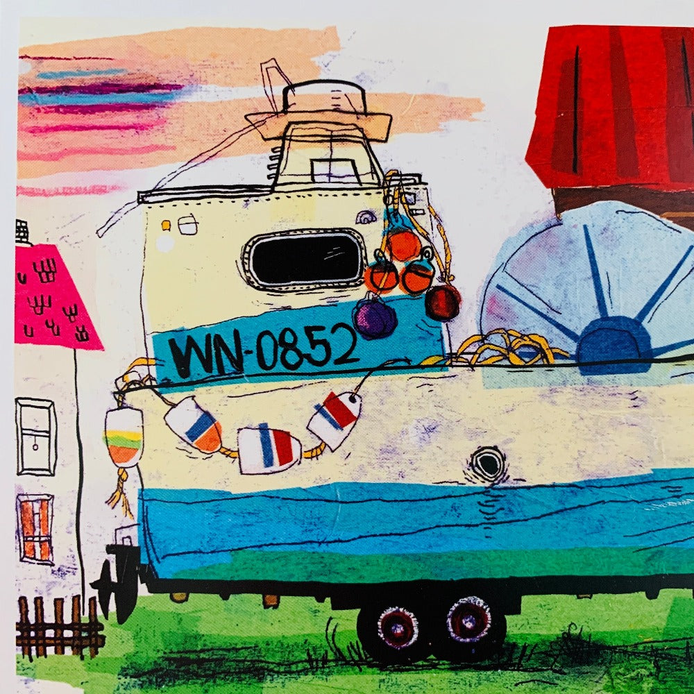 Close-up detail of a greeting card printed with a tissue-paper and ink painting of an old fishing boat in a yard.
