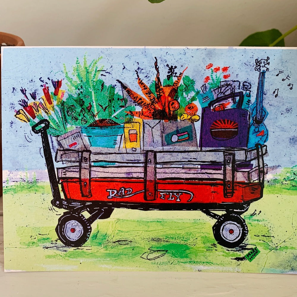 A greeting card featuring a colorful painting of a red wagon full of groceries. Part of our Island Life series.