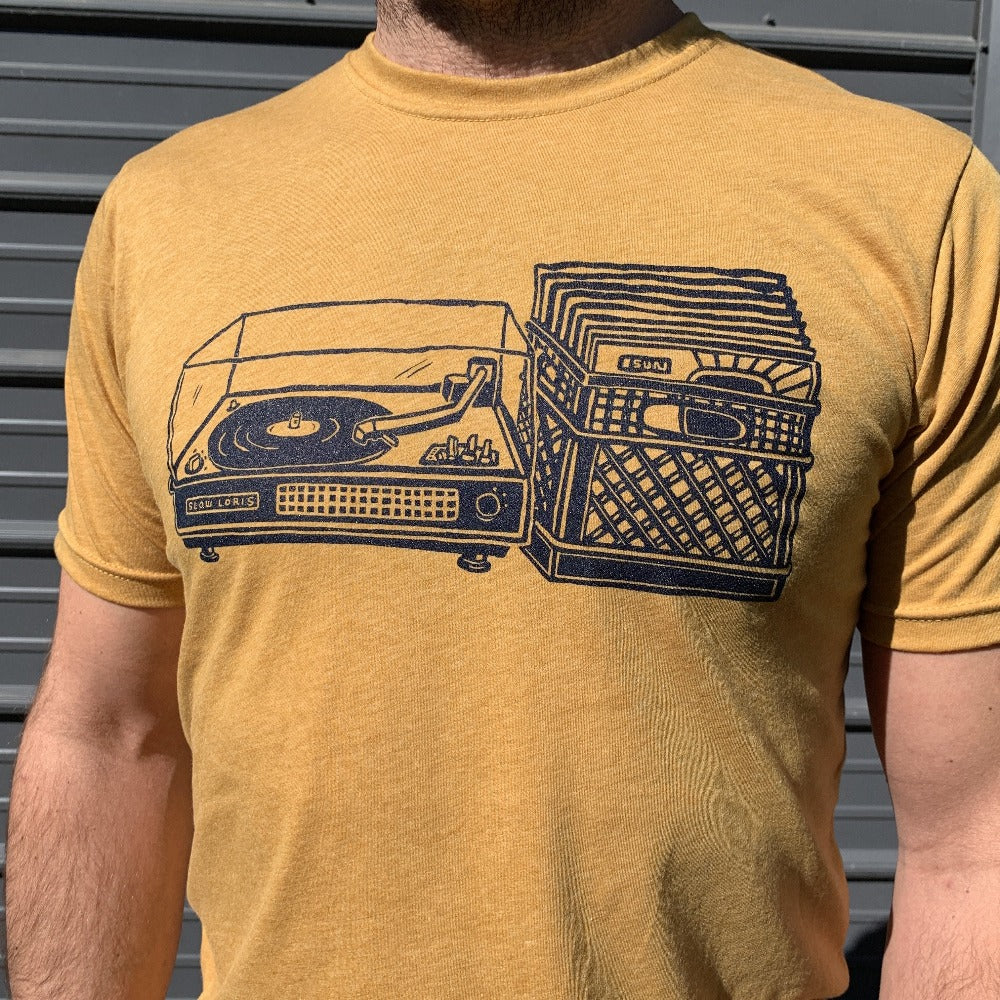 yellow shirt with black print of a record player with a milk crate full of records next to it.