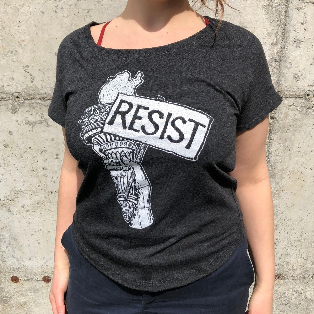 resist tee on a women outside, resistance, resist sticker, dump trump, Anti-Elon Musk, gay love, gay rights, protect trans kids, protect lgqtq rights, fuck trump, fuck musk, cyberpunk resistance, fascist billionaire, black maga hat, maga Elon hat, Elon Musk is a fascist sticker, anti-authoritarian tech sticker, resist billionaire control decal, no billionaires no fascism sticker, stop tech overlords sticker, anti-censorship sticker, laptop sticker,