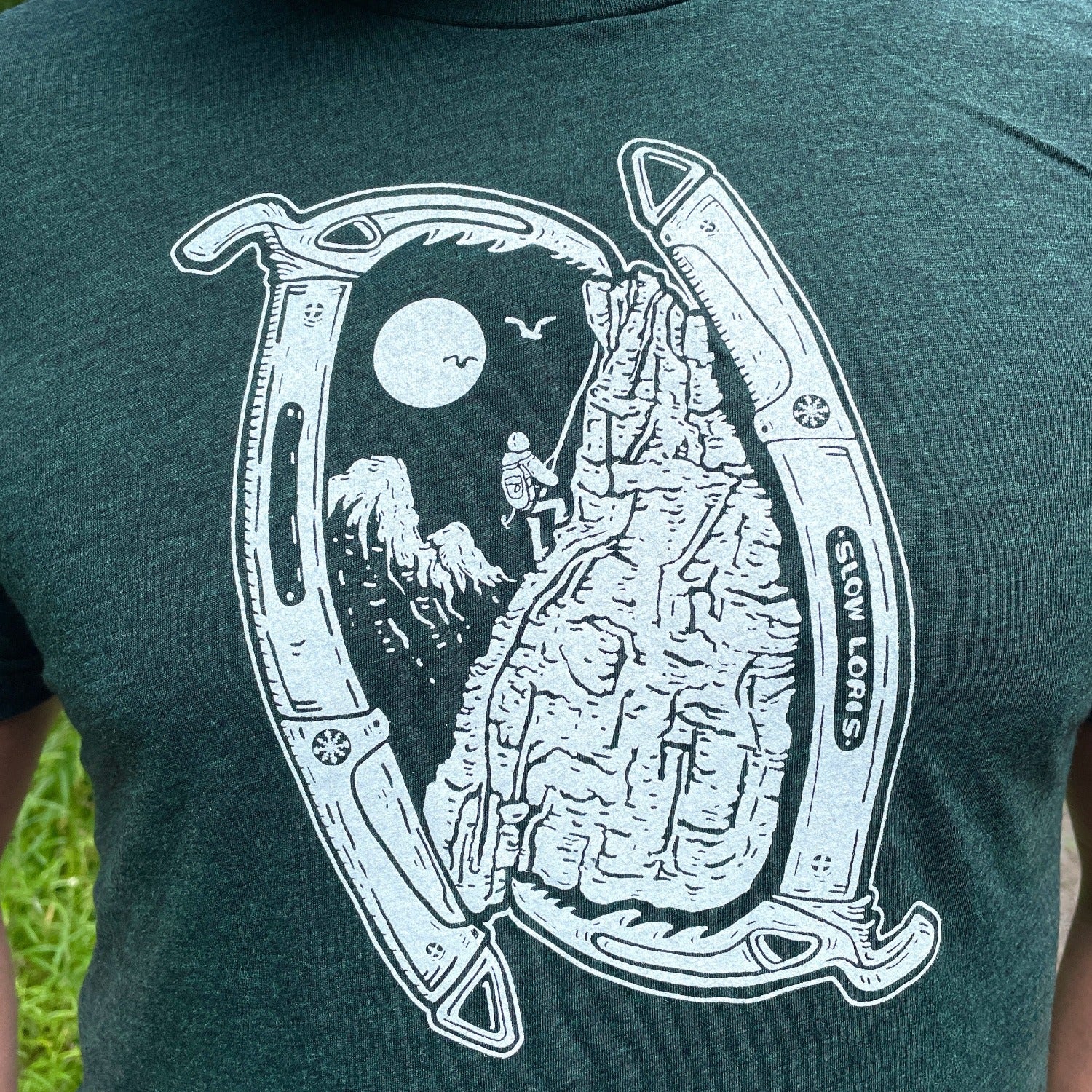 green t-shirt with ice Axes framing a climbing scene.