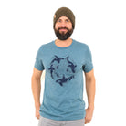 Bearded man wearing beanie with light blue shirt and dark blue print of orcas swimming in a circle