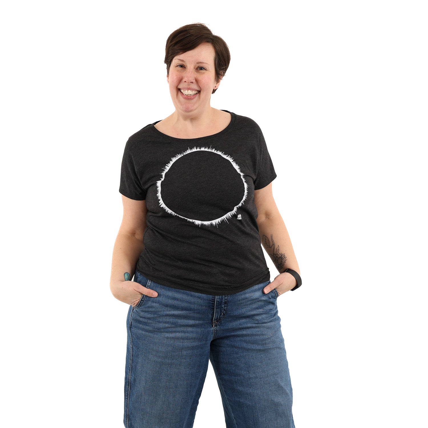 Woman smiling big wearing a black t-shirt with white ink of an eclipse.