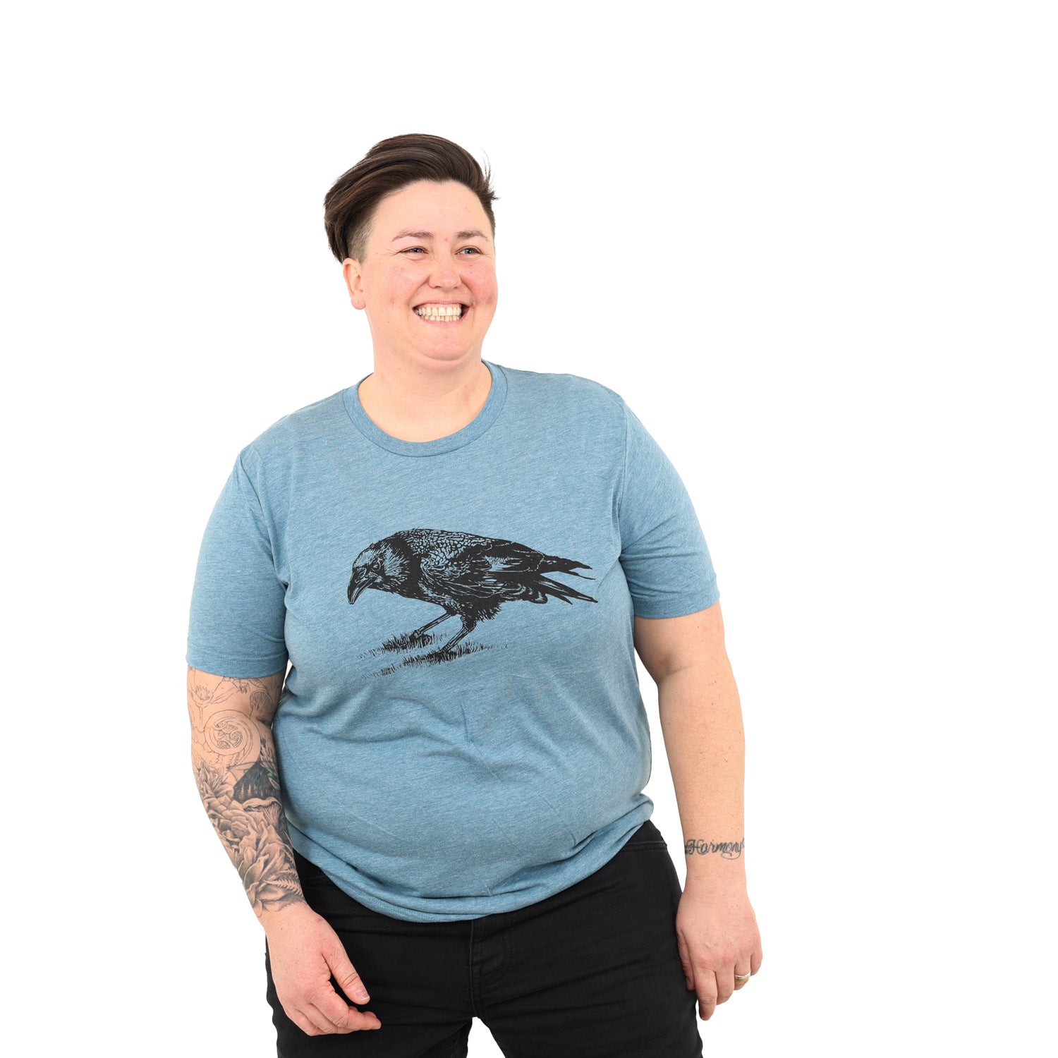smiling woman wearing blue shirt with a screenprinted crow on it. 