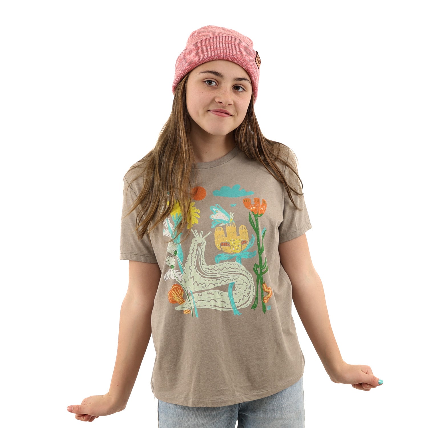 Girl  wearing light brown t shirt with colorful print of plants and bugs