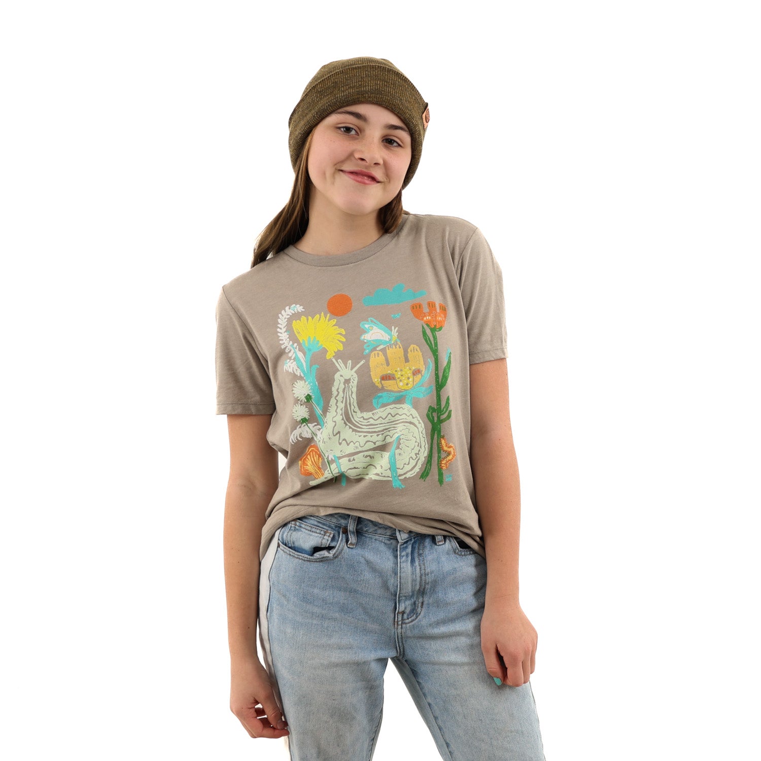 Girl wearing light brown t shirt with colorful print of plants and bugs