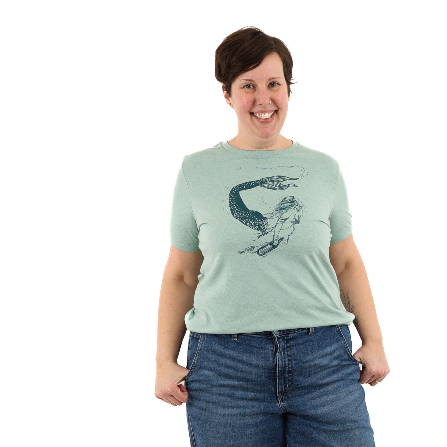 Woman wearing light green t shirt with a mermaid printed in green ink