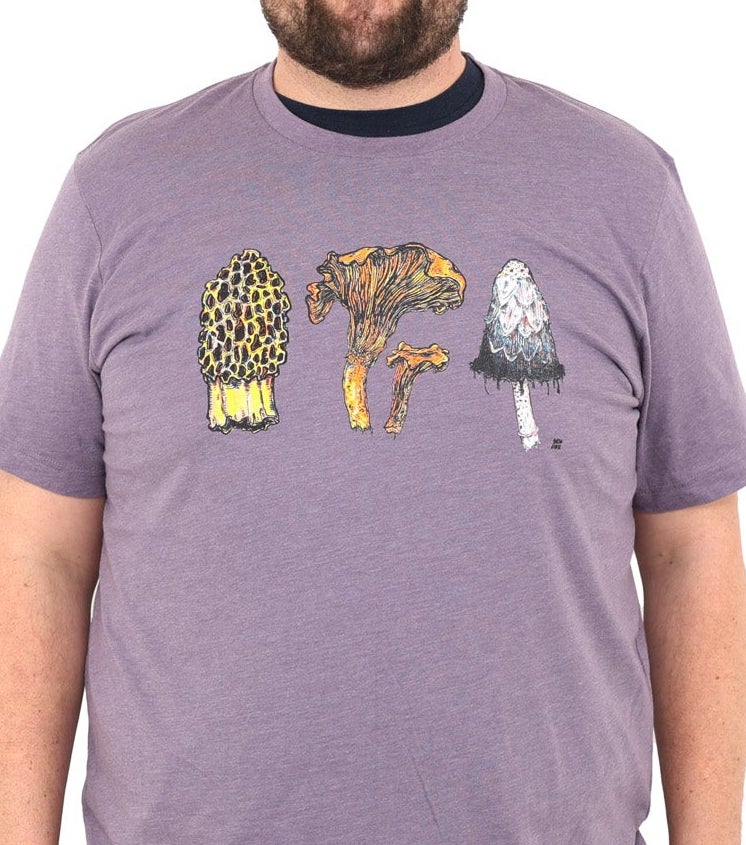 man wearing a light purple colored shirt with three mushrooms- morel, chantrelle, and shaggy mane