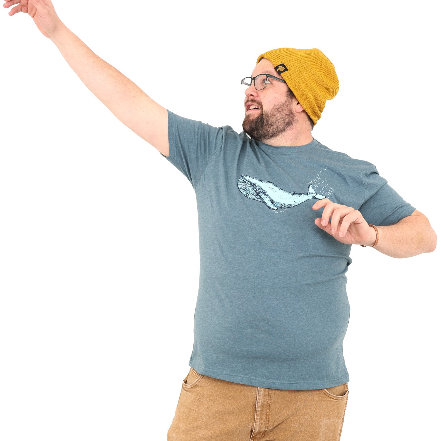 Man with hand in the air wearing a blue/grey t-shirt that has a blue whale screen printed on it. 