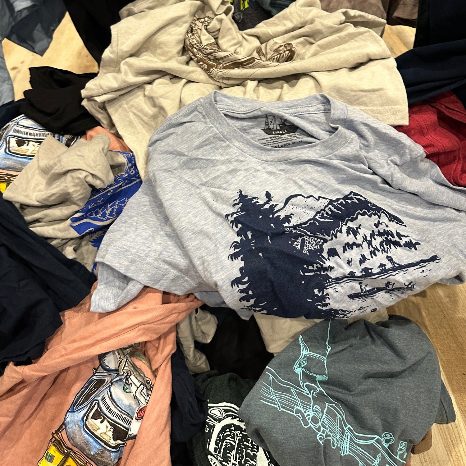 pile of different colored t-shirts with different designs and colors of inks. 