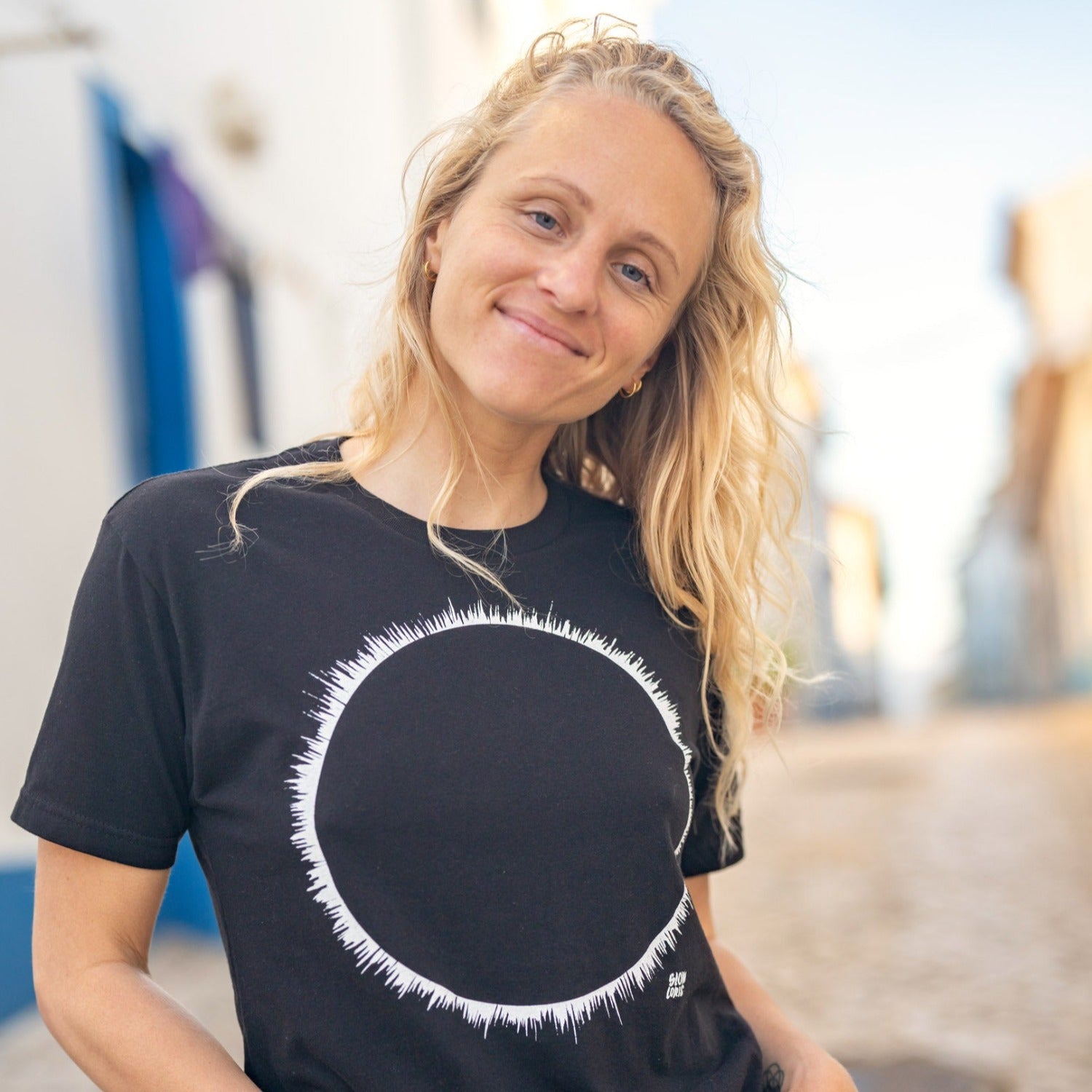 Close up of woman with long hair wearing black t-shirt with white eclipse print.