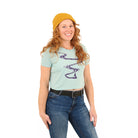 Girl wearing yellow hat and blue shirt with a ski line and a skier/snowboarder at the bottom