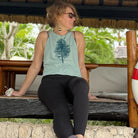 Girl sitting holding flower and looking to the side