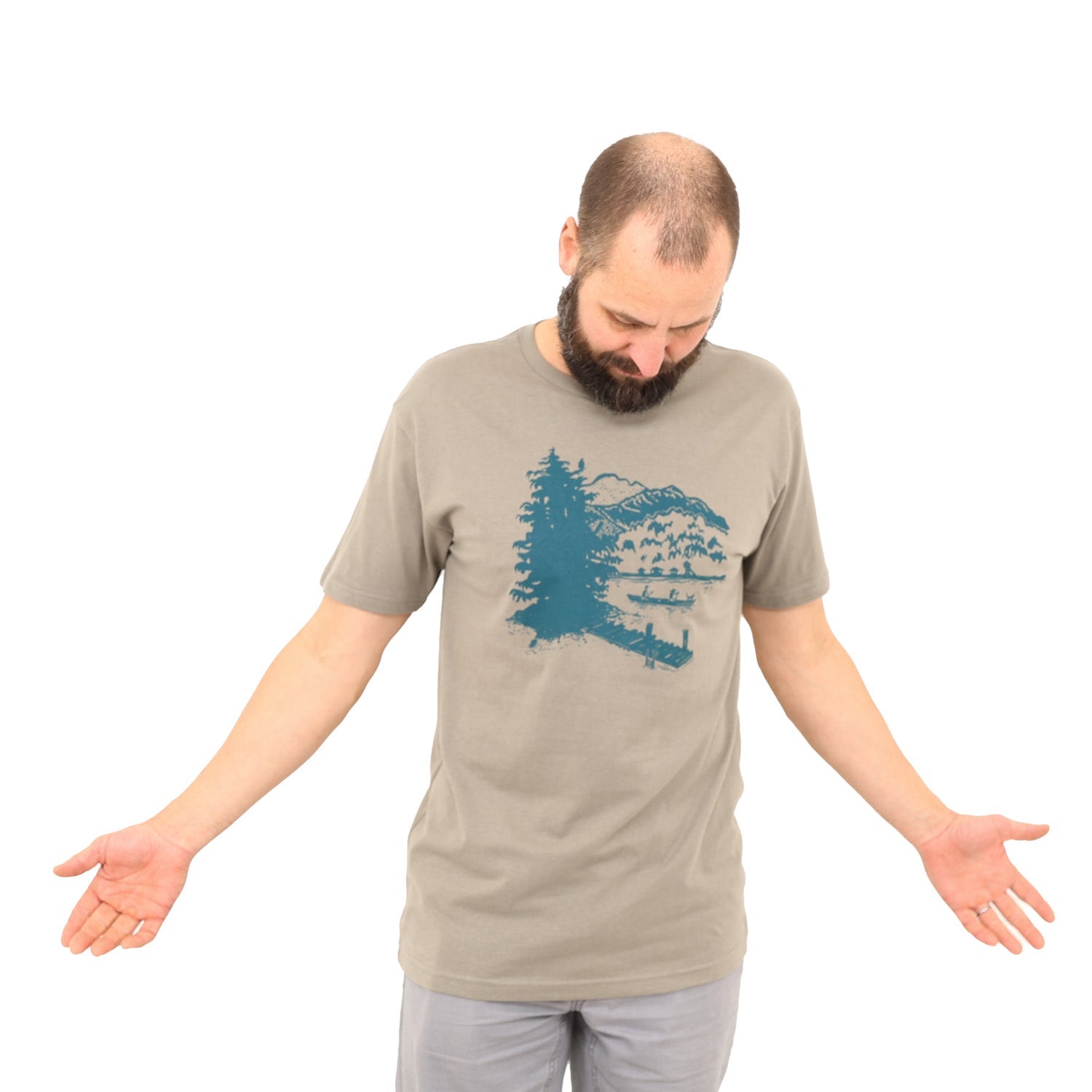 Man wearing a warm grey t-shirt with a green print of lakeside scene on it.