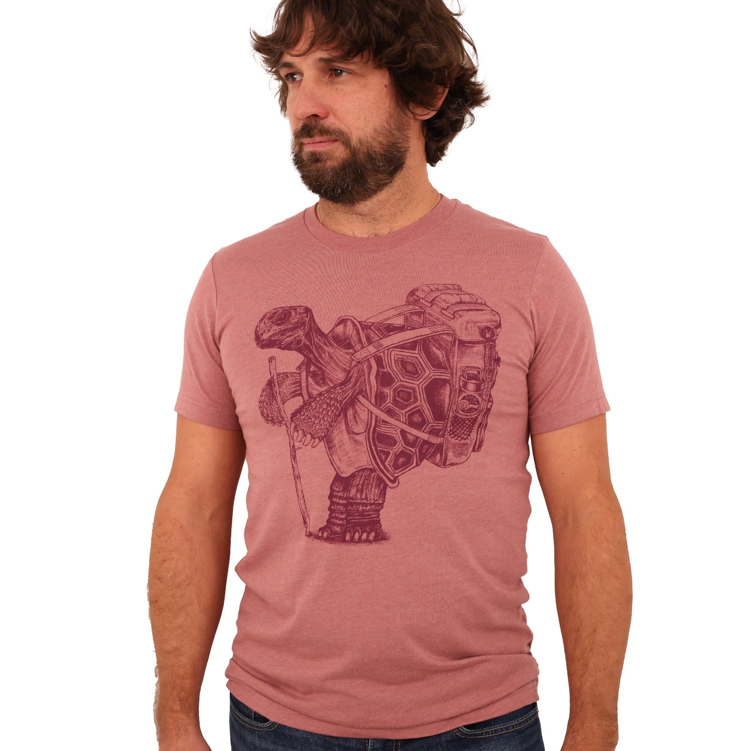 man wearing mauve shirt with darker mauve ink of a hiking tortoise.