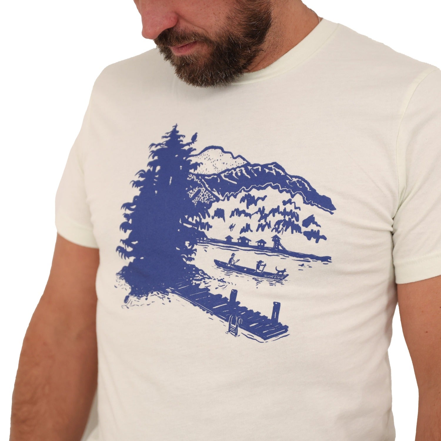Close up of citron(light tan) t-shirt with blue print of lakeside scene