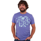 Man wearing a light purple colored t-shirt with light blue ink of flowers, ferns, feathers, shells, etc