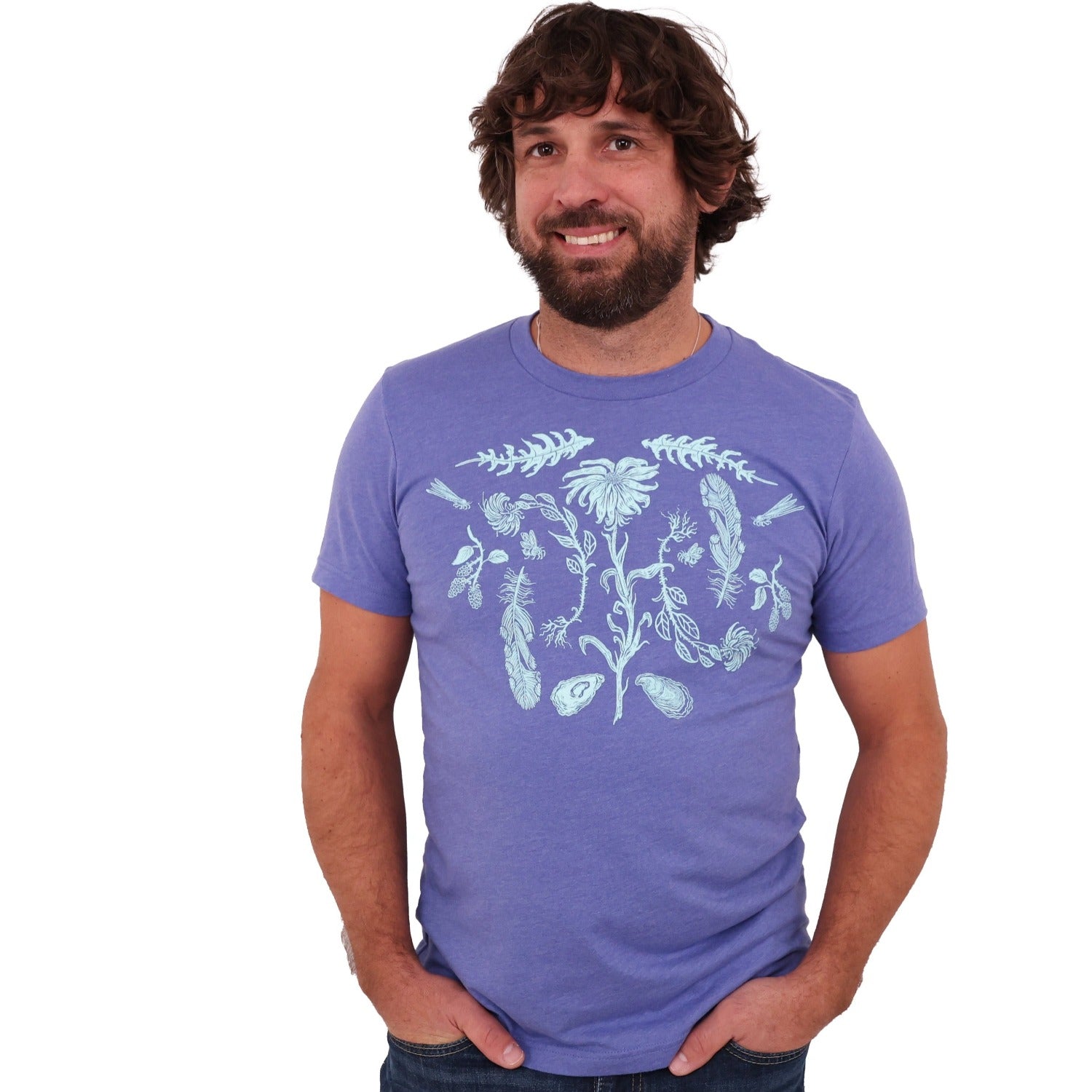 Man wearing a light purple colored t-shirt with light blue ink of flowers, ferns, feathers, shells, etc