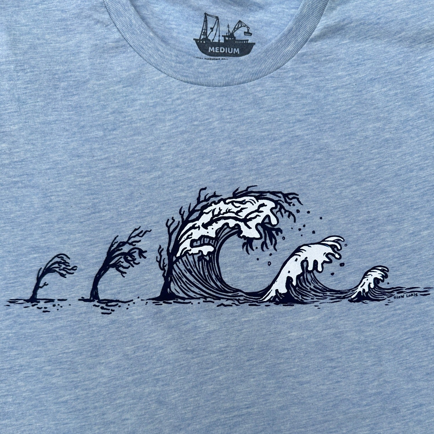 light blue tee with trees turning to waves across the chest.