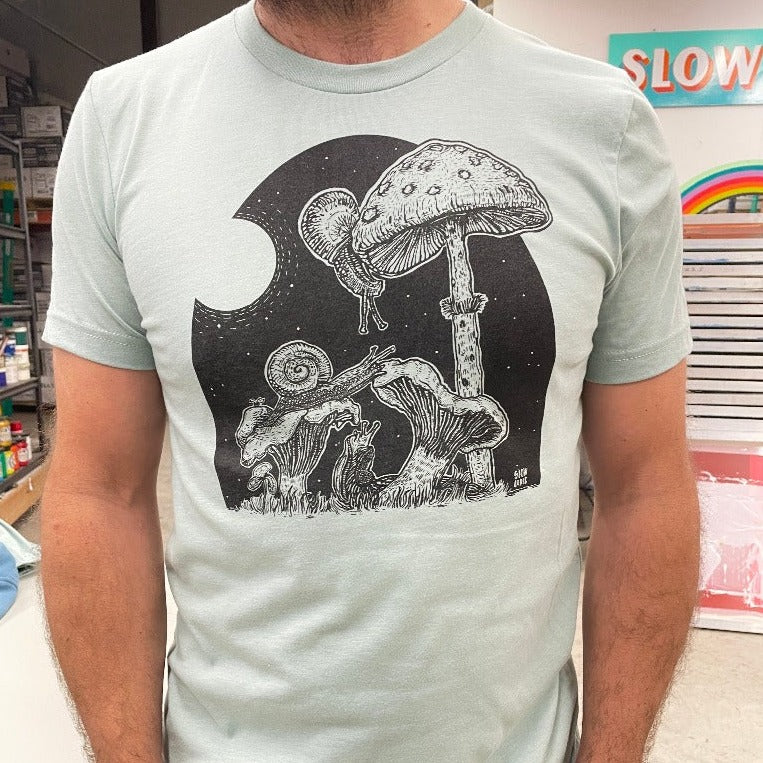 man's torso wearing light mint shirt with snails eating mushrooms in the full moon light.